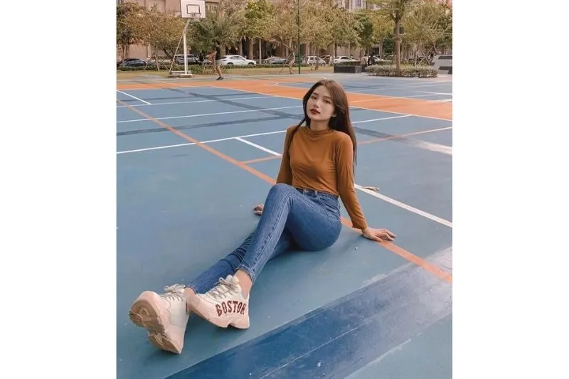 Tạo dáng ngồi khoe giày và đôi chân thon dài